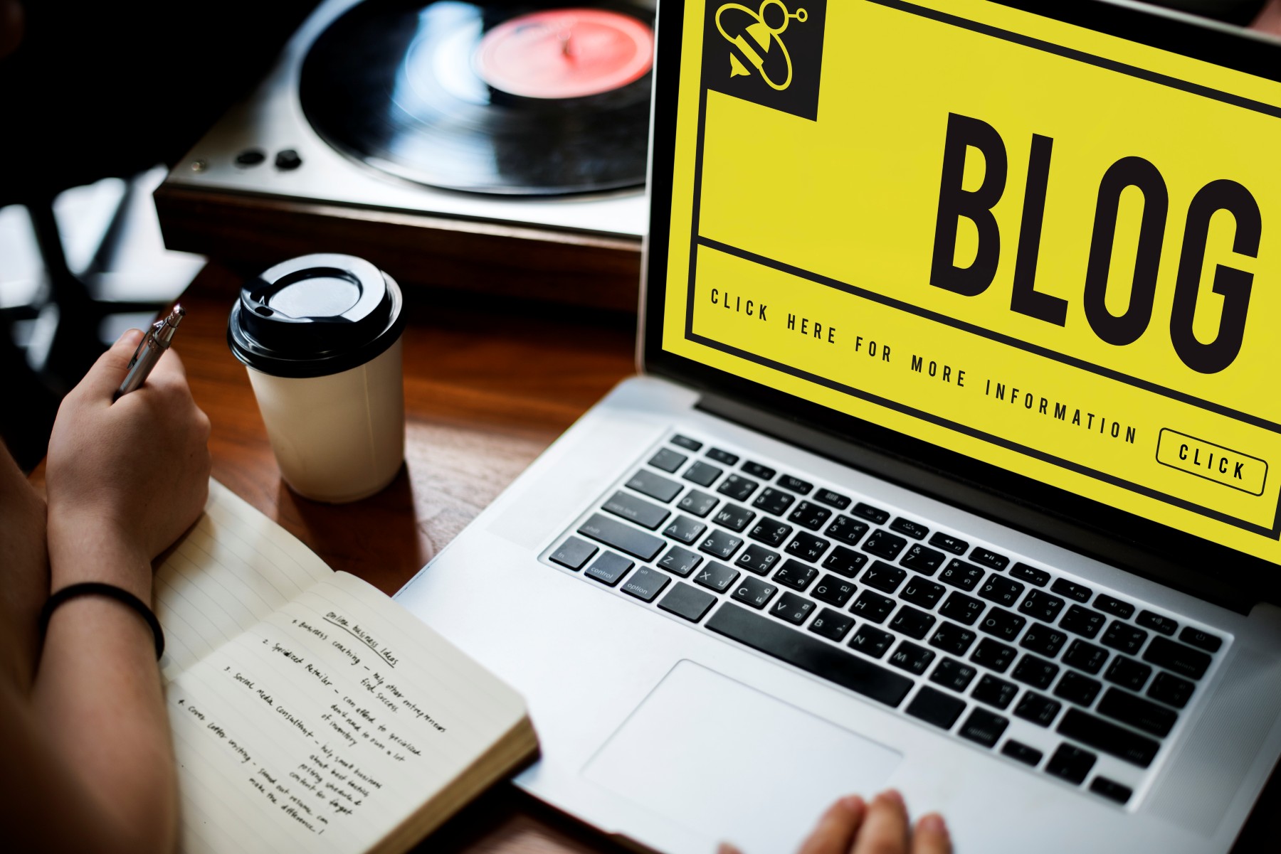 Hands typing on a laptop with a blog layout open on screen.
